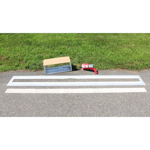 Multiple width parking line stencils displayed on a paved surface with a stencil holder and spray paint tool nearby.